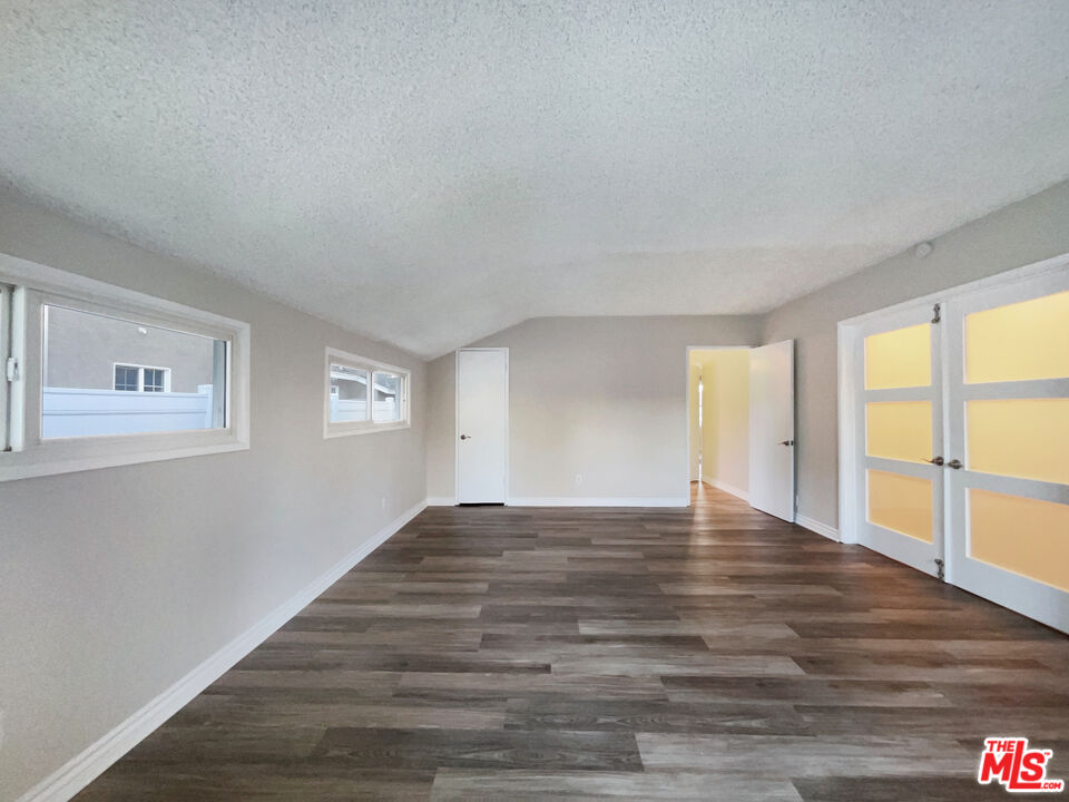 7944 Limerick Avenue Winnetka, CA 91306 - Photo 20 of 23 a view of an empty room with wooden floor and a window