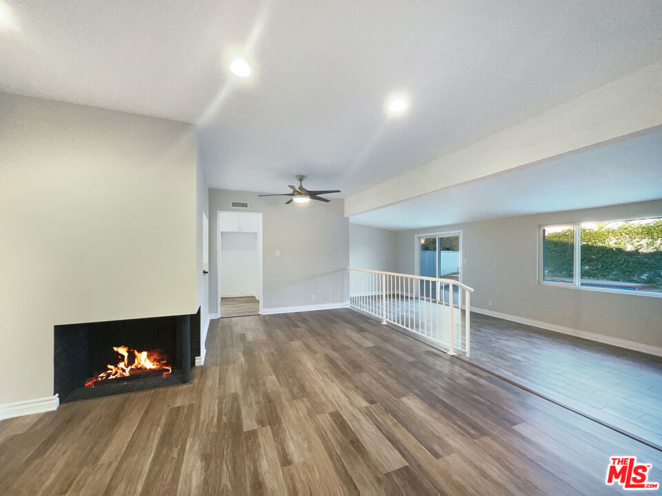 7944 Limerick Avenue Winnetka, CA 91306 - Photo 6 of 23 a view of empty room with a fireplace and wooden floor
