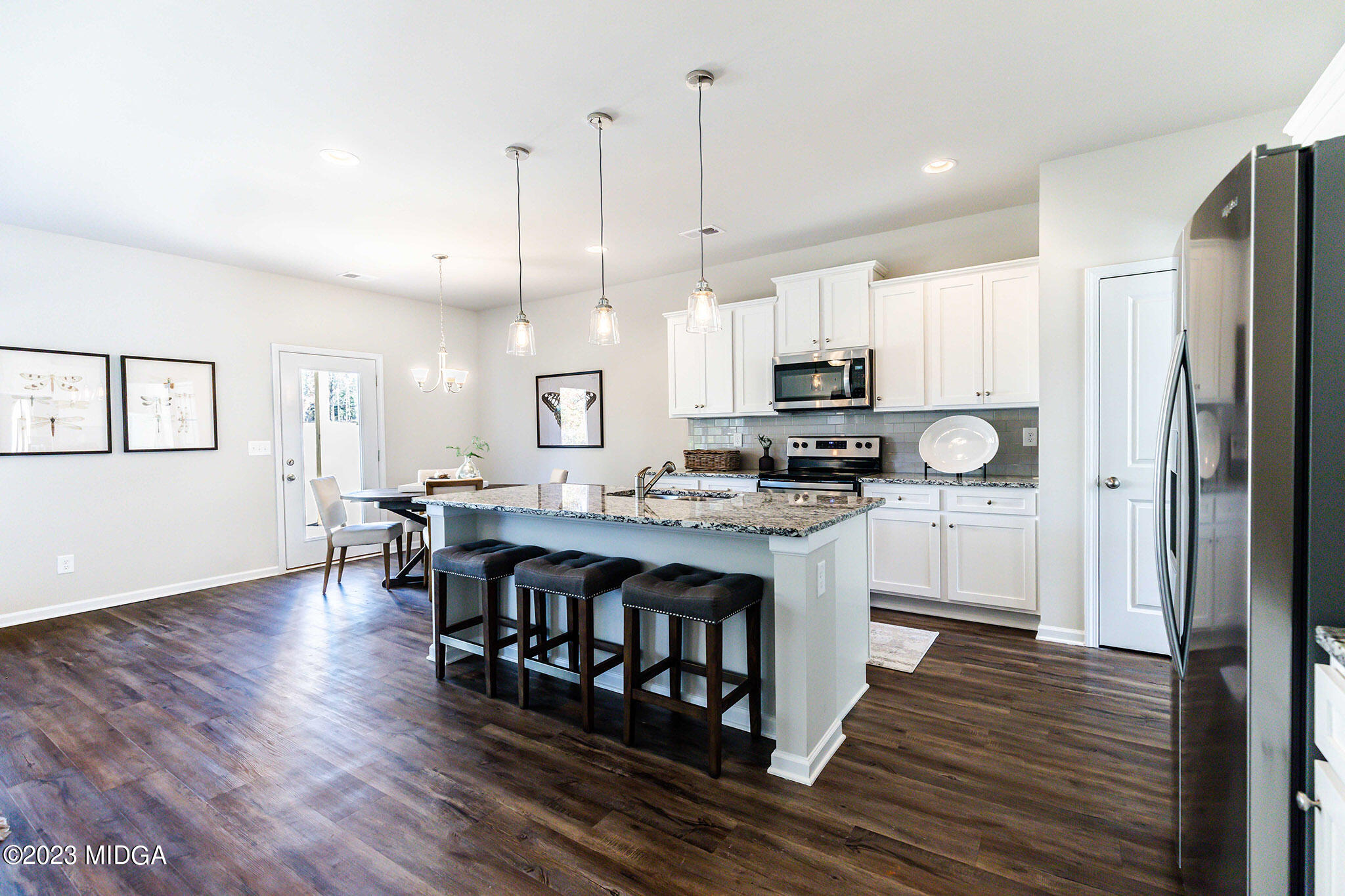 118 Red Birch Lane Warner Robins, GA 31093 - Photo 7 of 19 a kitchen with stainless steel appliances granite countertop a refrigerator a stove top oven a sink dishwasher and a dining table with wooden floor