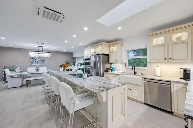 a kitchen with stainless steel appliances kitchen island granite countertop a sink and cabinets