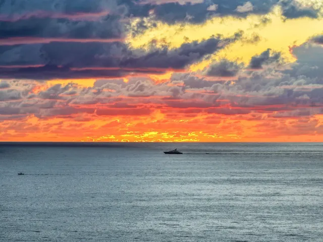 an aerial view of ocean and residential houses with outdoor space