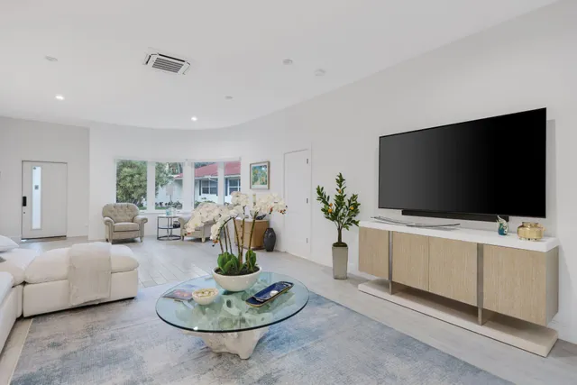 a kitchen with stainless steel appliances kitchen island granite countertop a sink dishwasher and white cabinets with wooden floor