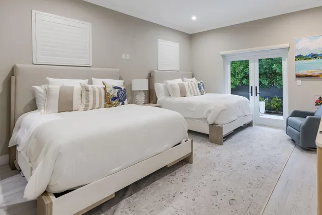 a large bedroom with two beds and large window