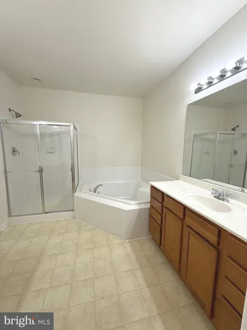 a spacious bathroom with a tub sink and mirror