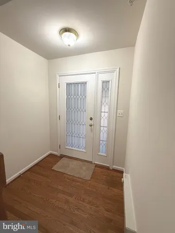 an empty room with wooden floor and mirror