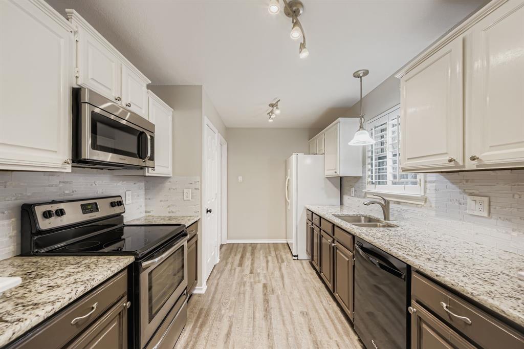 5416 Catlow Valley Road Fort Worth, TX 76137 - Photo 12 of 28 a kitchen with stainless steel appliances granite countertop a sink stove microwave and cabinets