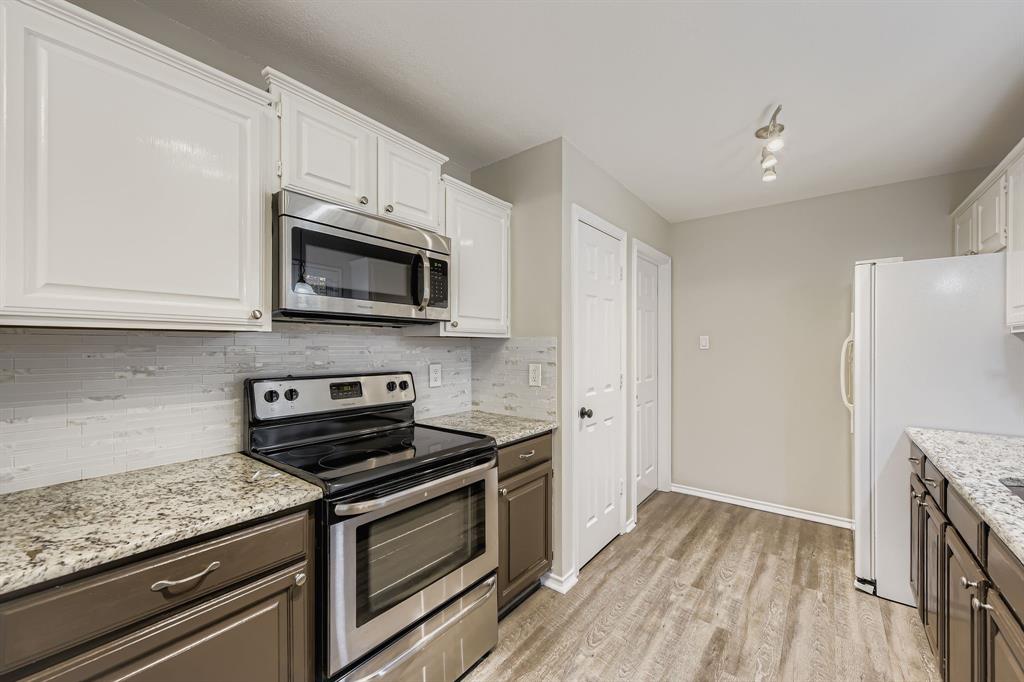5416 Catlow Valley Road Fort Worth, TX 76137 - Photo 13 of 28 a kitchen with stainless steel appliances granite countertop a stove microwave and cabinets