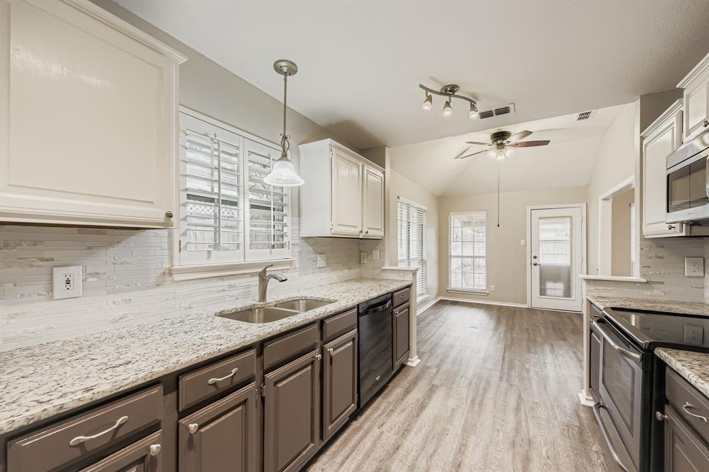 5416 Catlow Valley Road Fort Worth, TX 76137 - Photo 15 of 28 a kitchen with granite countertop a sink cabinets wooden floor and stainless steel appliances
