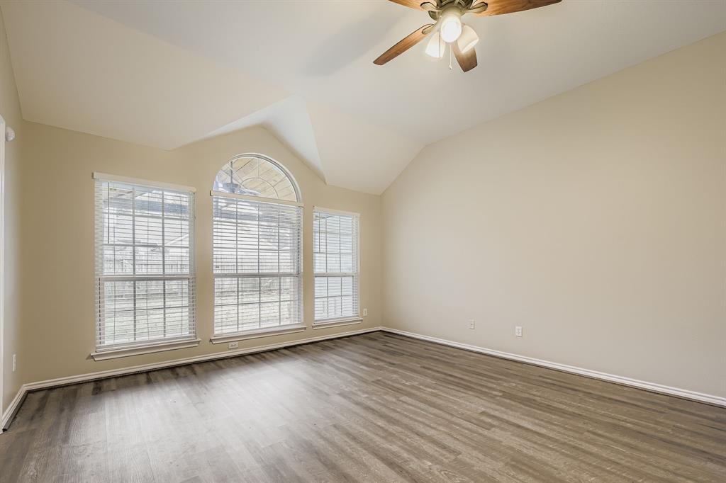 5416 Catlow Valley Road Fort Worth, TX 76137 - Photo 8 of 28 an empty room with wooden floor chandelier fan and windows