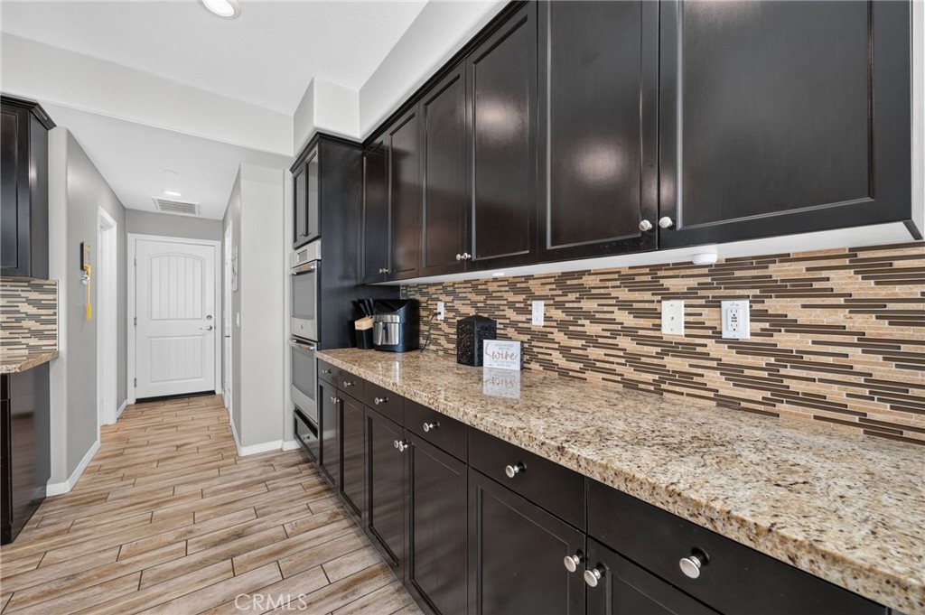 23347 Crystal Way Wildomar, CA 92595 - Photo 29 of 109 a kitchen with granite countertop stainless steel appliances and wooden cabinets
