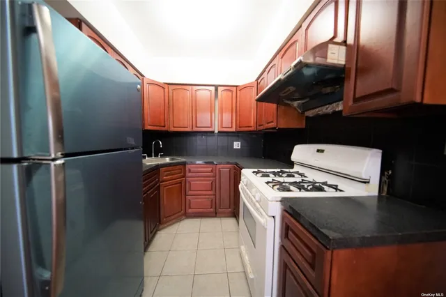 a kitchen with stainless steel appliances granite countertop a stove a sink and a refrigerator