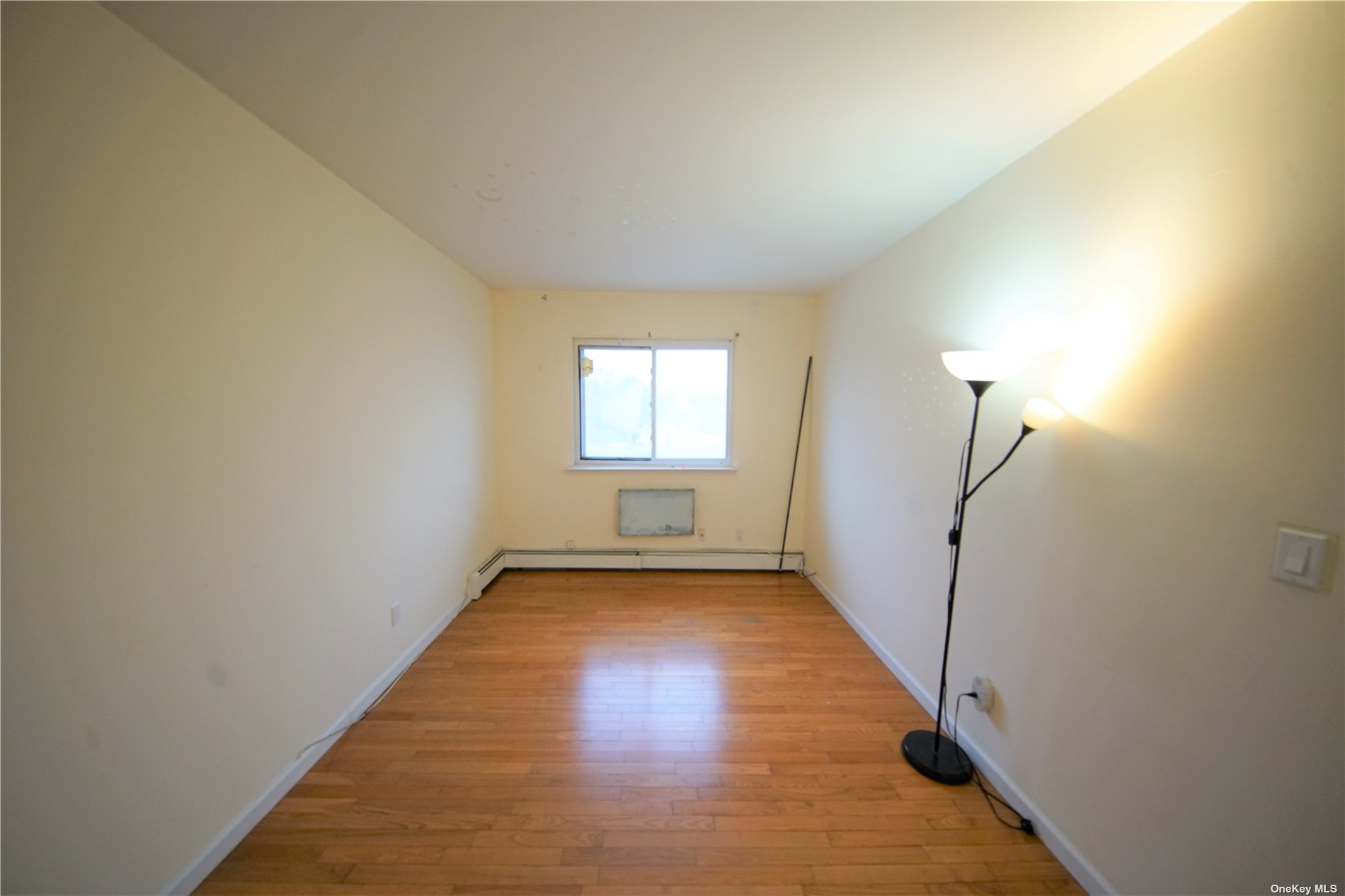 132-56 60th Avenue Queens, NY 11355 - Photo 7 of 8 a view of a room with wooden floor and window