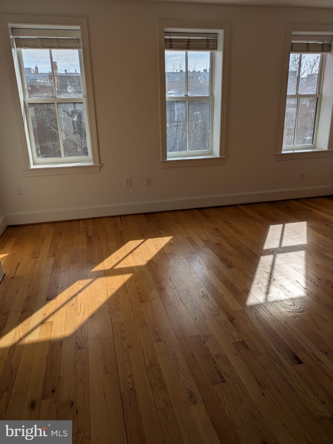 1421 Q Street Northwest, Unit 1 Washington, DC 20009 - Photo 16 of 19 an empty room with wooden floor and windows