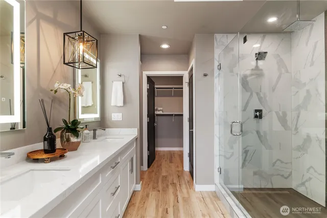 a bathroom with a double vanity sink a mirror and shower