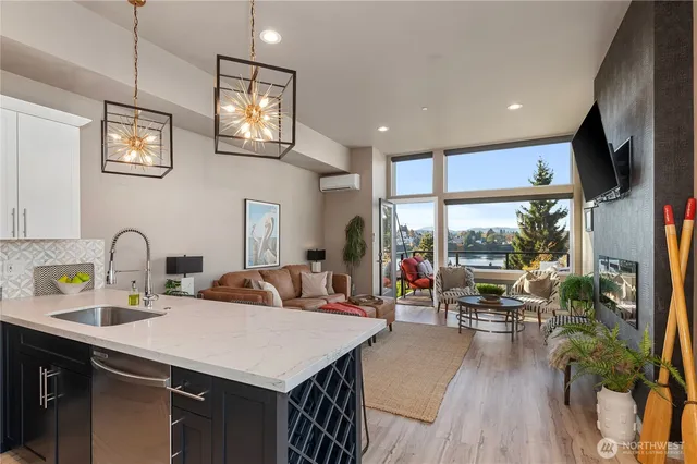 a kitchen with stainless steel appliances granite countertop a sink a stove and a wooden floors