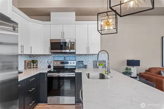 a kitchen with stainless steel appliances a stove a sink and a microwave