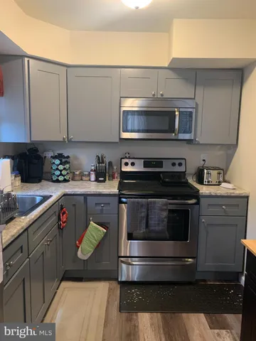 a kitchen with stainless steel appliances a stove a sink and a microwave