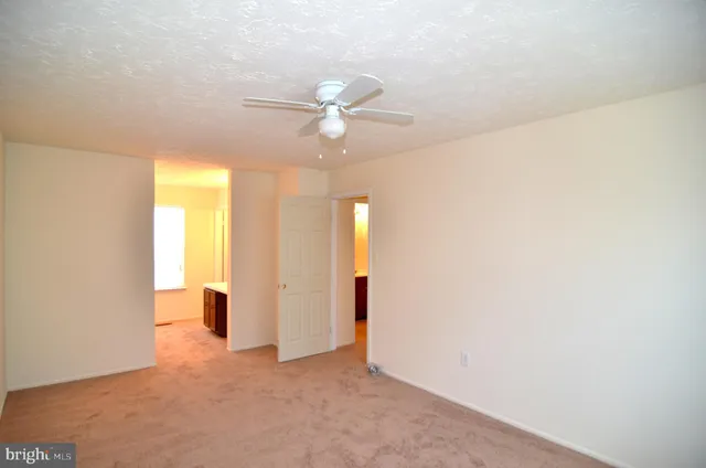 a view of a room with a ceiling fan and a window
