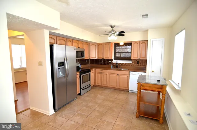 a kitchen with stainless steel appliances a refrigerator sink and cabinets
