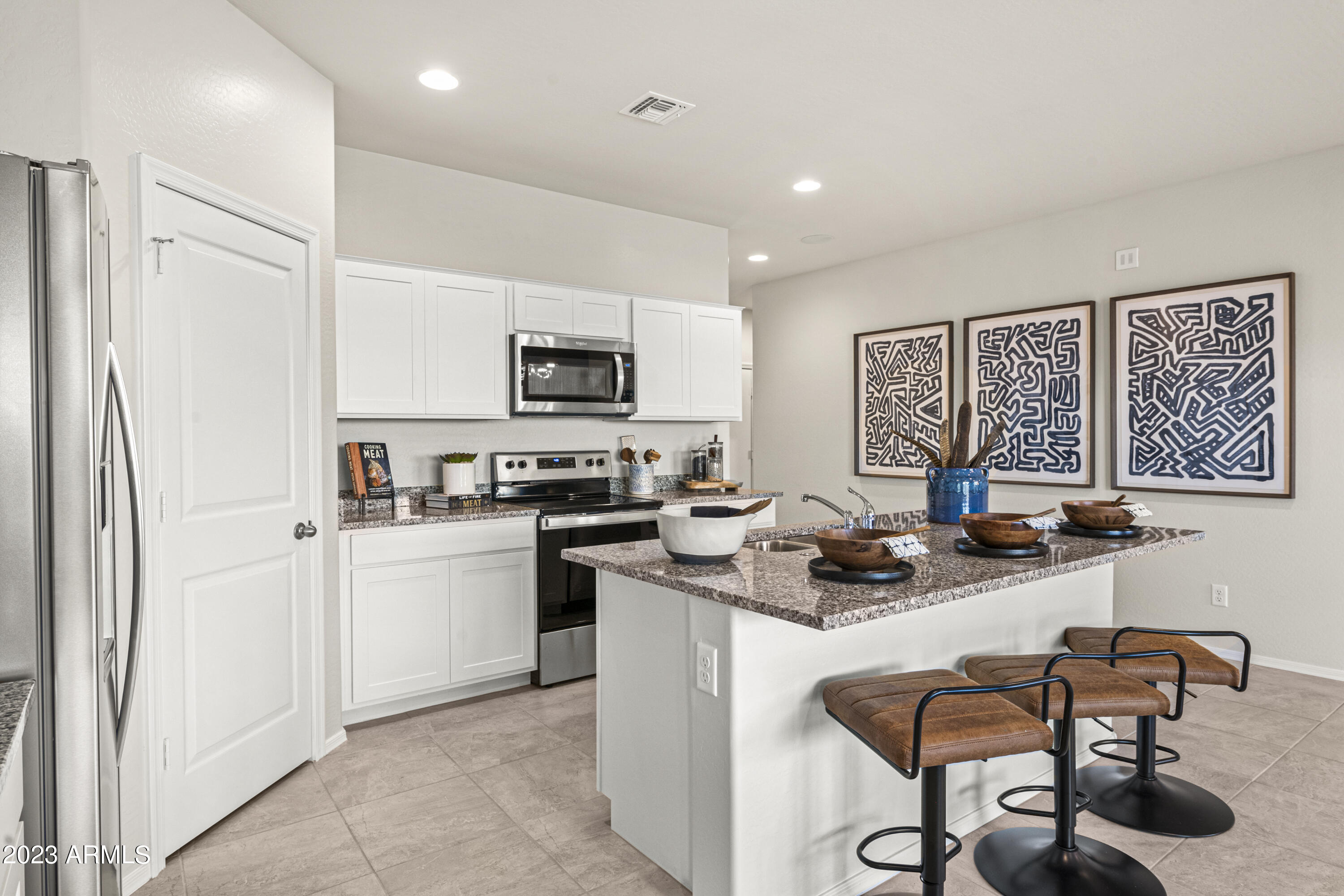 2374 West Solstice Avenue Apache Junction, AZ 85120 - Photo 22 of 59 a kitchen with stainless steel appliances granite countertop a stove top oven a sink a dining table and chairs