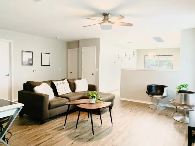 a living room with furniture and a wooden floor