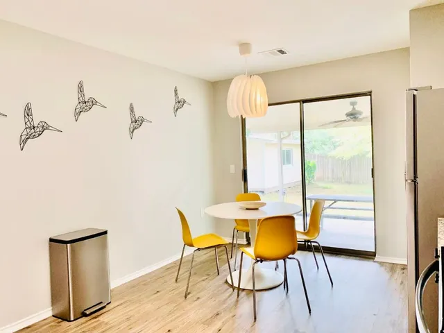 a view of a dining room with furniture a chandelier and wooden floor