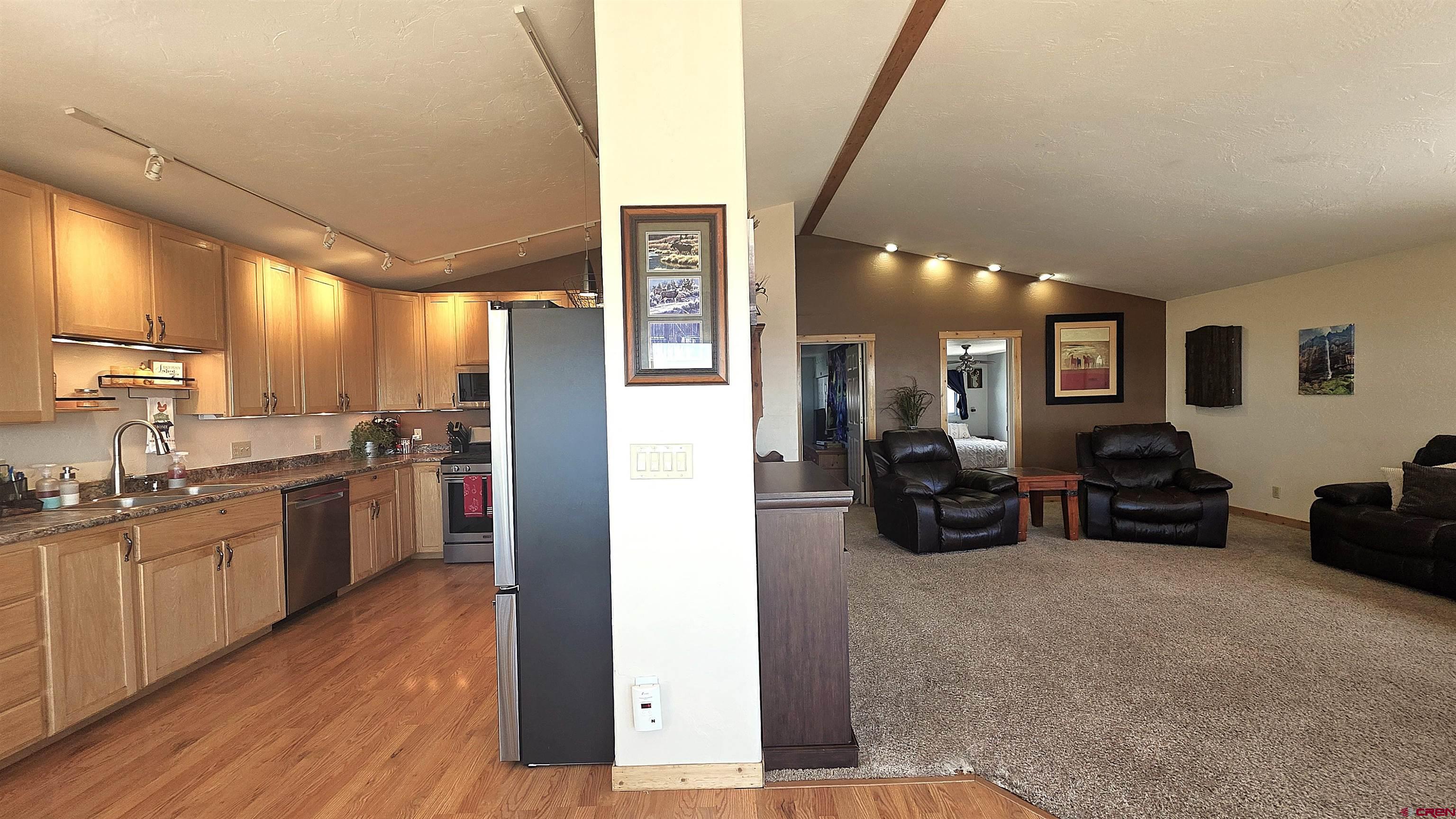 21976 2225th Road Cedaredge, CO 81413 - Photo 9 of 36 a kitchen with stainless steel appliances granite countertop a refrigerator a sink dishwasher a dining table and chairs with wooden floor