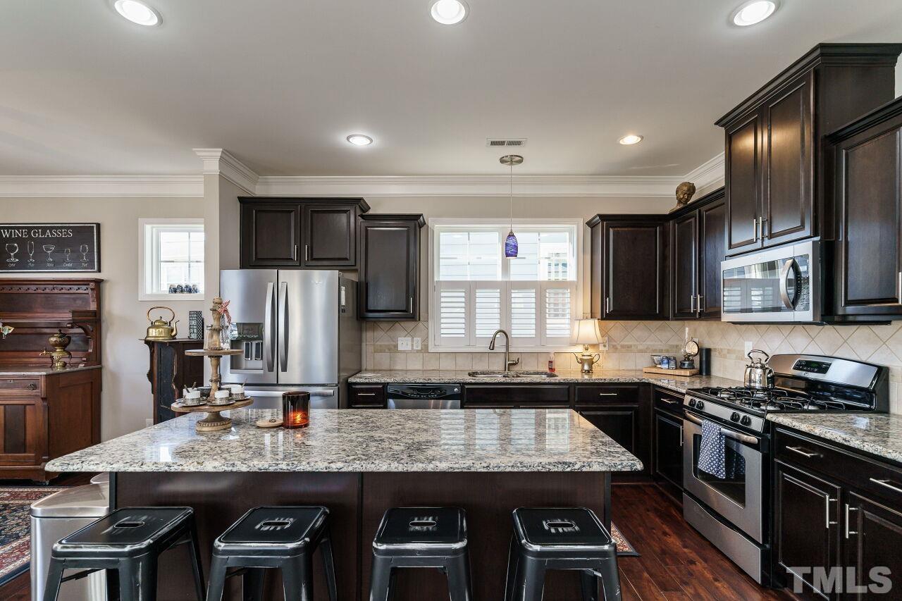 1344 Rodessa Run Raleigh, NC 27607 - Photo 15 of 38 a kitchen with stainless steel appliances granite countertop a sink stove and refrigerator