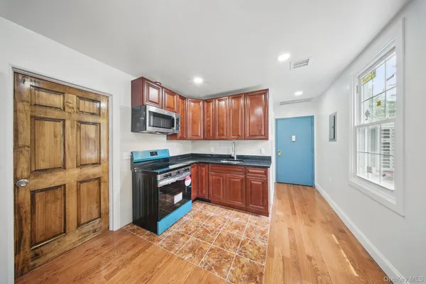 a kitchen with stainless steel appliances granite countertop a refrigerator sink and wooden cabinets