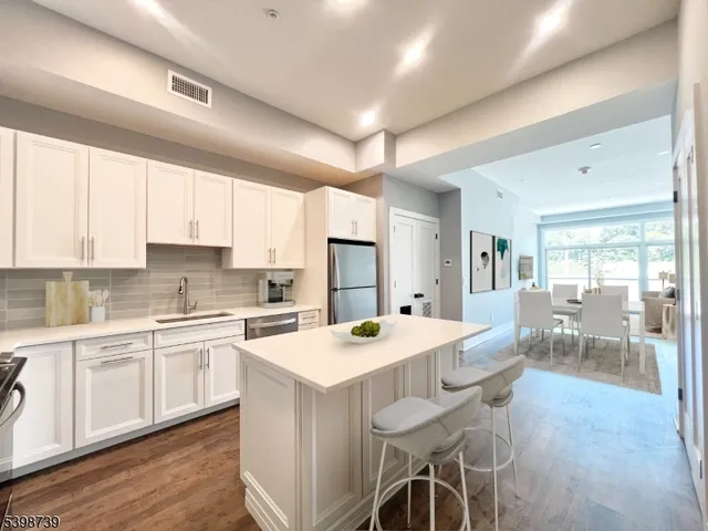 a kitchen with a dining table chairs and white cabinets