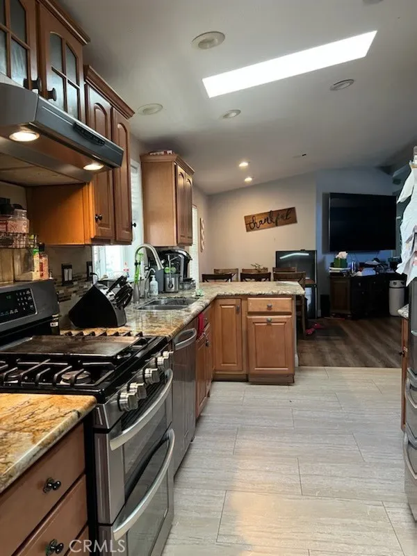 1616 South Euclid Street, Unit 54 Anaheim, CA 92802 - Photo 2 of 11 a large kitchen with stainless steel appliances granite countertop a stove and a sink