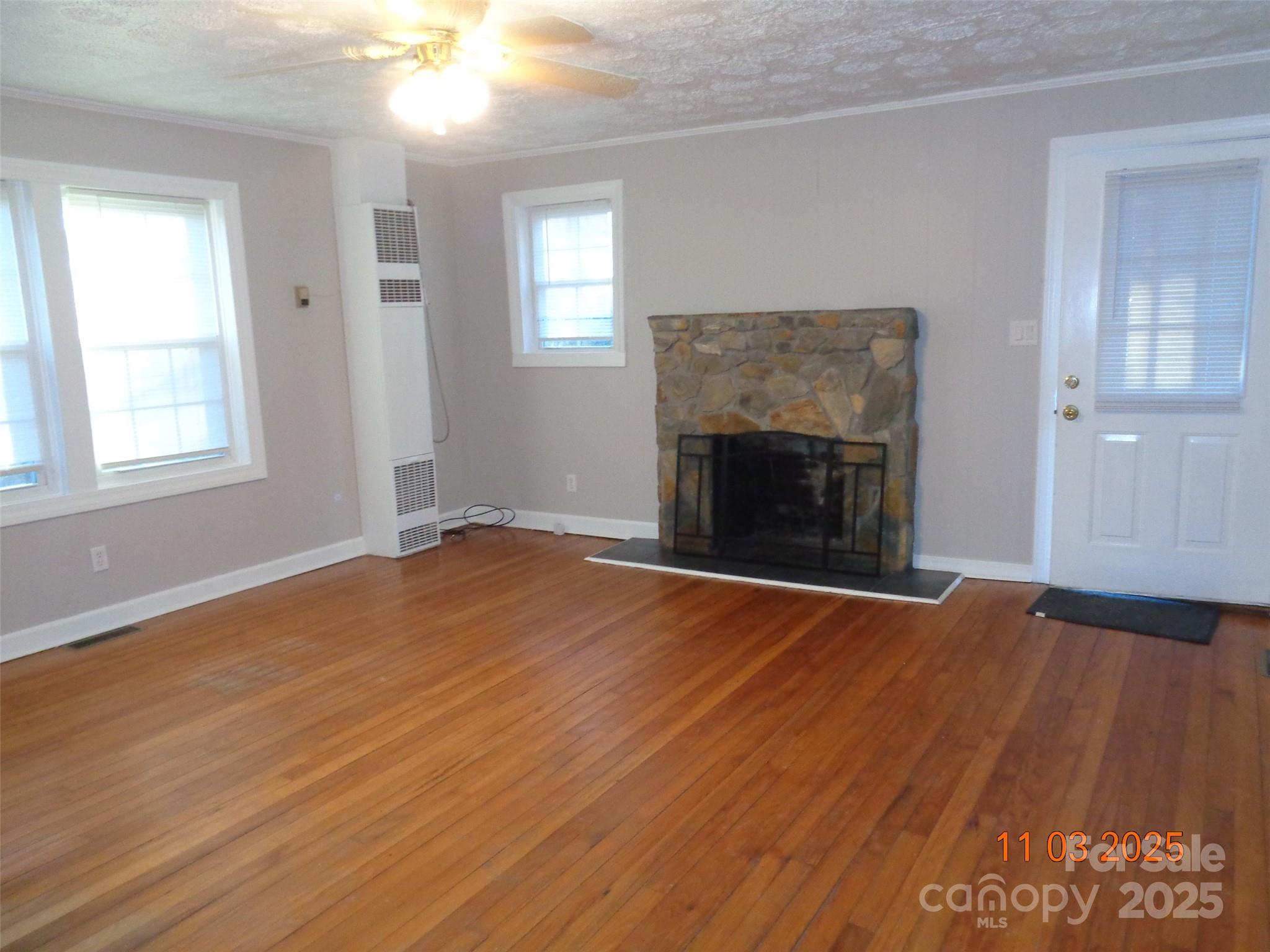 1412 Walt Arney Road Lenoir, NC 28645 - Photo 12 of 20 an empty room with wooden floor fireplace and windows