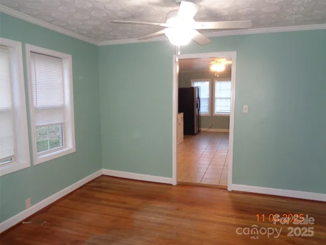 a view of empty room with window and wooden floor