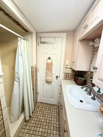 a bathroom with a sink a toilet a mirror and shower