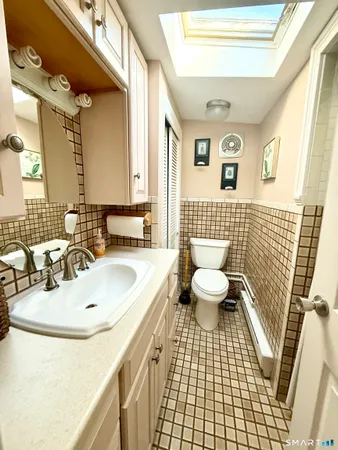 a bathroom with a sink a toilet a mirror and shower