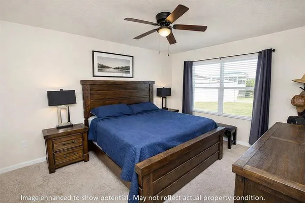a bedroom with a bed a chandelier and a window