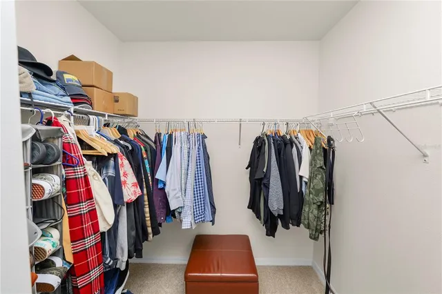 a view of walk in closet with clothes and shoes