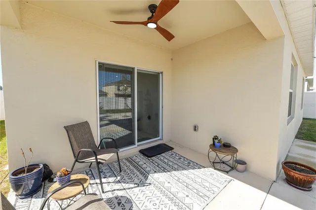a view of a patio with a dining table and chairs under an umbrella with a fire pit