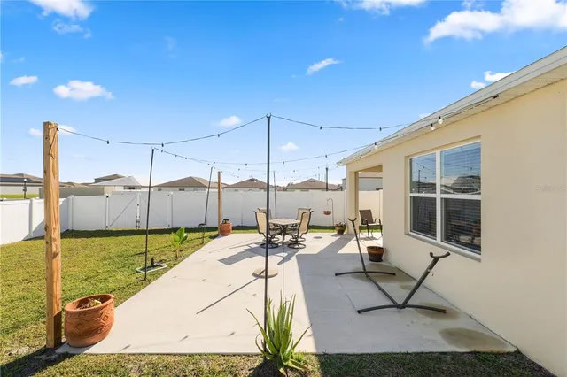 a view of a patio with dining table and chairs under an umbrella