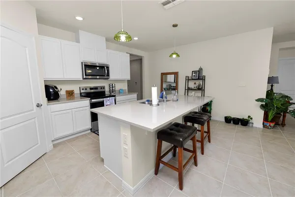 a kitchen with a sink a microwave and cabinets
