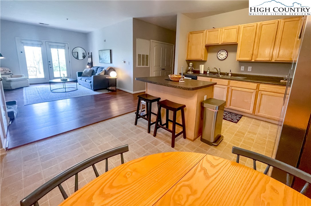 190 Eli Hartley Drive, Unit 112 Boone, NC 28607 - Photo 4 of 20 a room with stainless steel appliances kitchen island granite countertop a table chairs in it and a large window