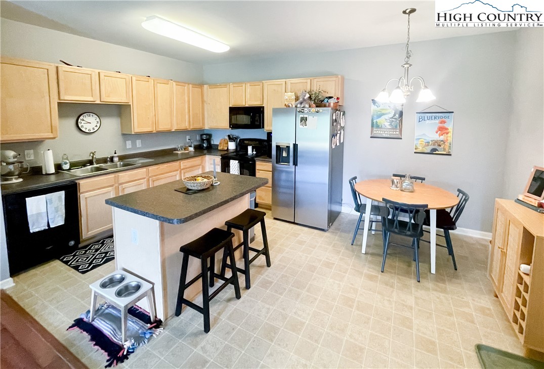 190 Eli Hartley Drive, Unit 112 Boone, NC 28607 - Photo 5 of 20 a kitchen with a dining table chairs and refrigerator