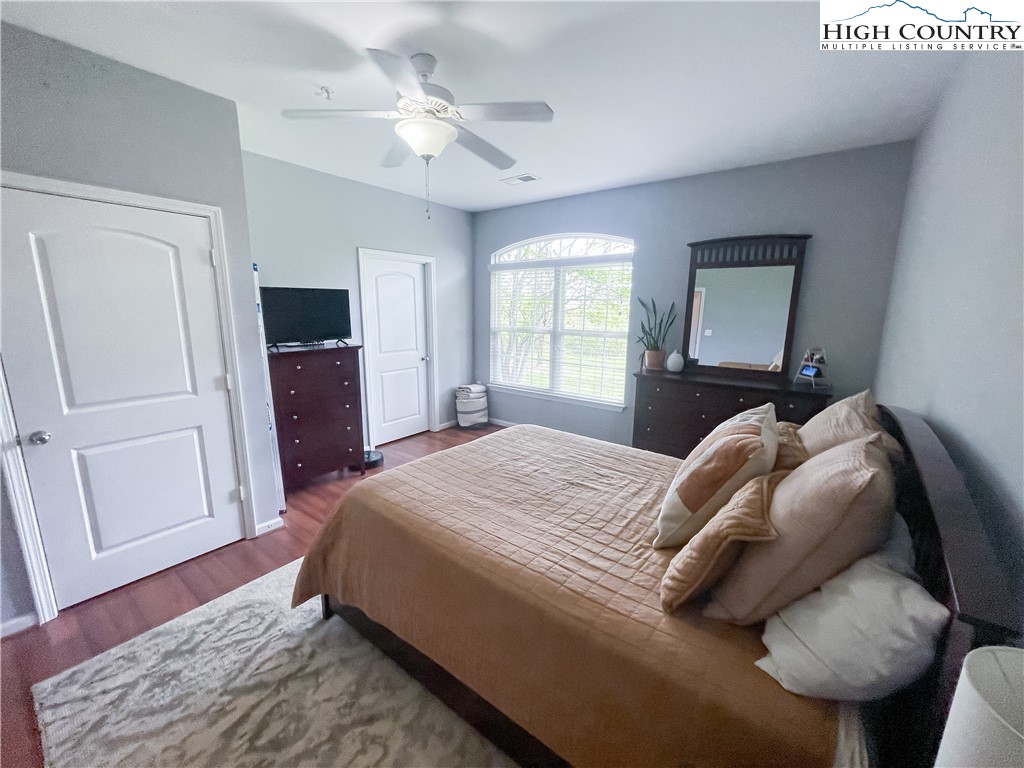 190 Eli Hartley Drive, Unit 112 Boone, NC 28607 - Photo 9 of 20 a bedroom with a bed and a dresser with wooden floor