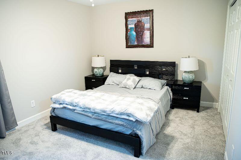 141 Jones Franklin Road, Unit E Raleigh, NC 27606 - Photo 13 of 20 a bedroom with a bed and lamp
