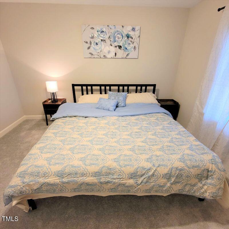 141 Jones Franklin Road, Unit E Raleigh, NC 27606 - Photo 14 of 20 a large bed sitting in a bedroom next to a wall