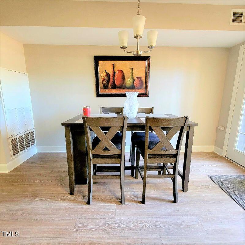 141 Jones Franklin Road, Unit E Raleigh, NC 27606 - Photo 8 of 20 a view of a dining room with furniture and wooden floor