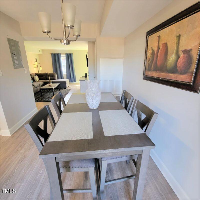 141 Jones Franklin Road, Unit E Raleigh, NC 27606 - Photo 9 of 20 a view of a dining room with furniture and a chandelier