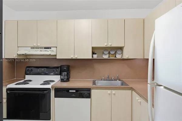 a kitchen with a sink a stove and cabinets