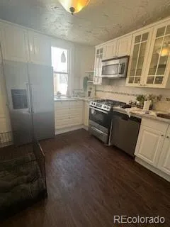 a kitchen with stainless steel appliances granite countertop a refrigerator a stove a sink and a microwave