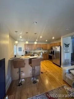 a living room with stainless steel appliances lots of furniture and kitchen view